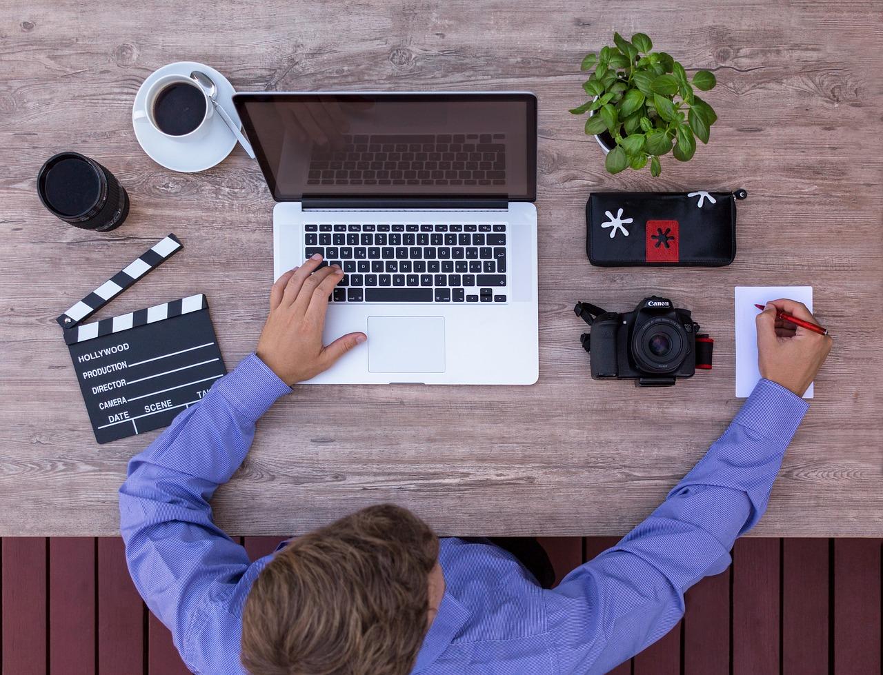 Espacio de trabajo audiovisual completo con ordenador, claqueta y cámara, representando el ecosistema de recursos creativos.