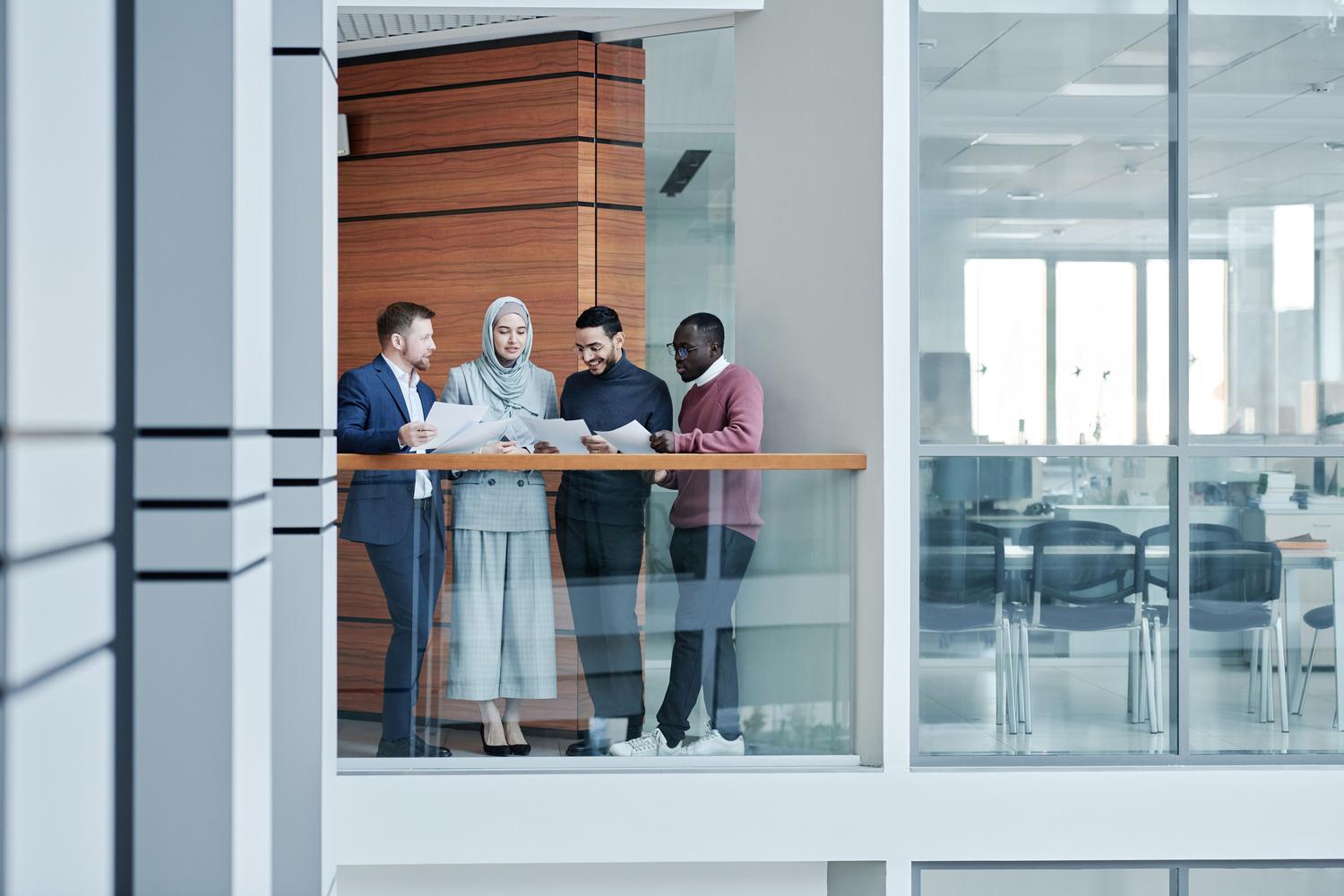 Equipo multidisciplinar y diverso colaborando en una oficina moderna, reflejando la mitigación de sesgos en la contratación