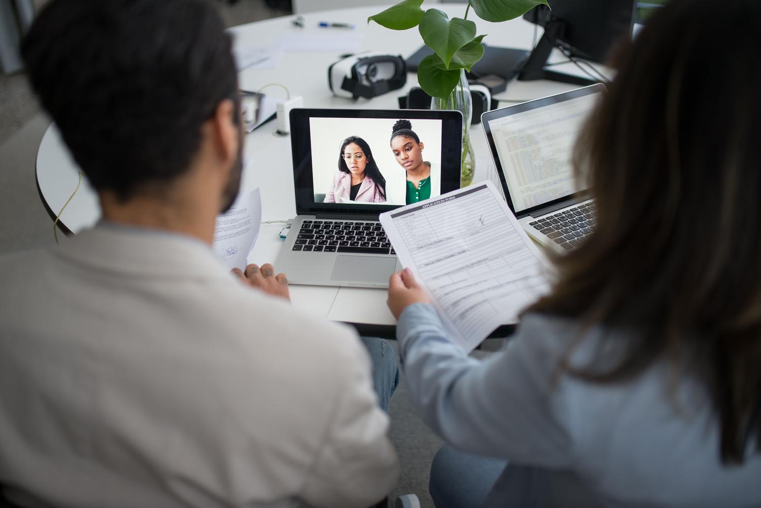 Entrevista de trabajo virtual a través de laptops, representando la digitalización y automatización de los procesos de selección