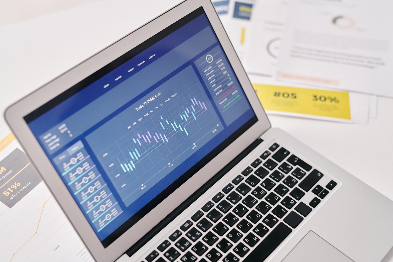 Laptop con dashboards financieros y reportes de ventas, ilustrando las herramientas de forecasting y análisis de ROI.