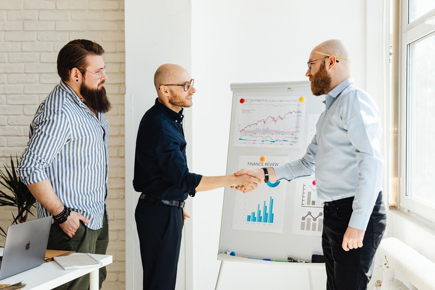 Profesionales de ventas B2B colaborando en una oficina con gráficos de datos, simbolizando la sinergia entre la IA y la toma de decisiones humana.