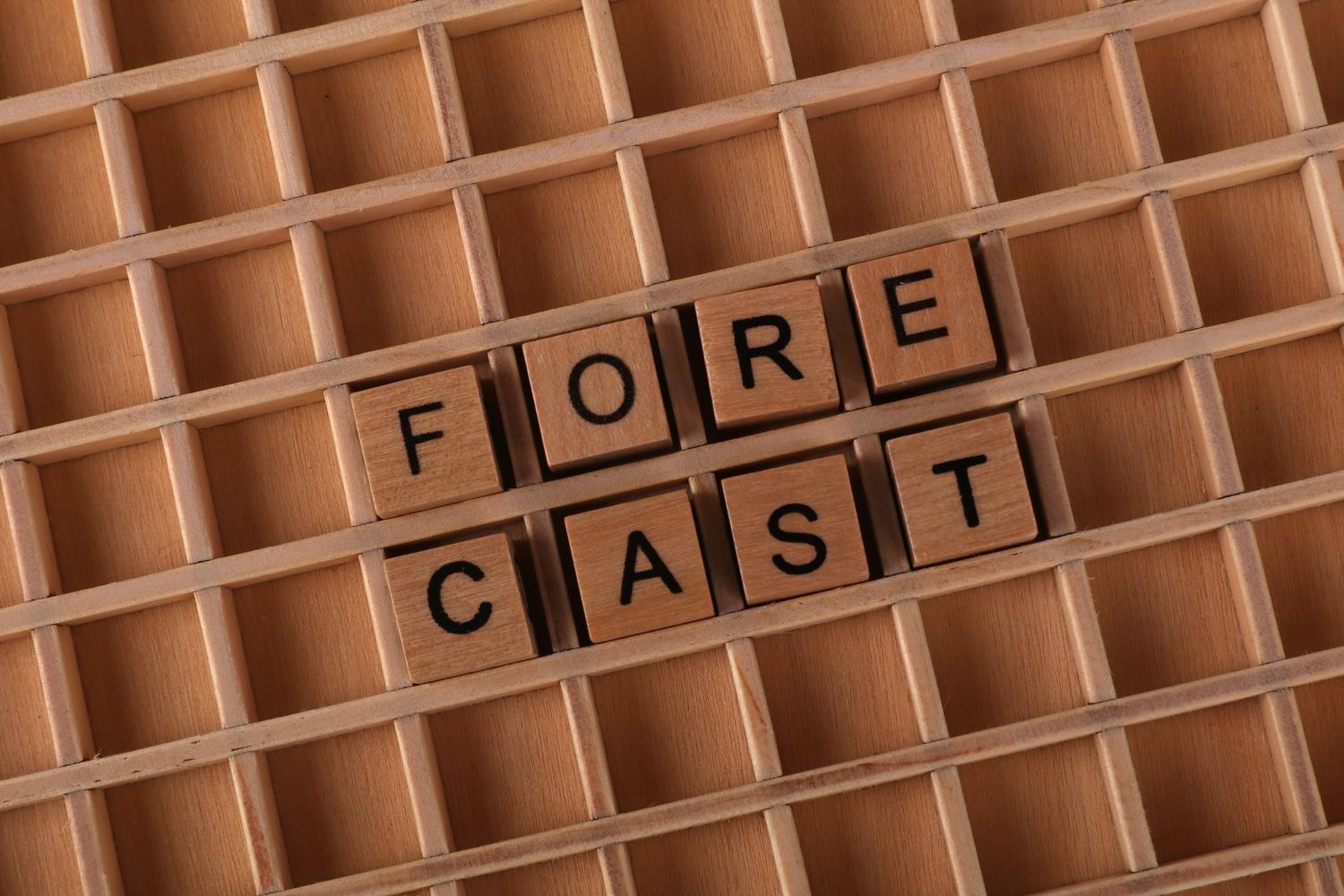 Representación conceptual de la palabra 'FORECAST' con fichas de madera, simbolizando la previsión y el pronóstico en el análisis predictivo.