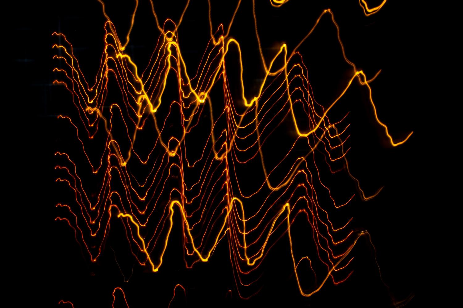 Ondas de luz abstractas y coloridas sobre un fondo negro, simbolizando la generación de sonido mediante inteligencia artificial.