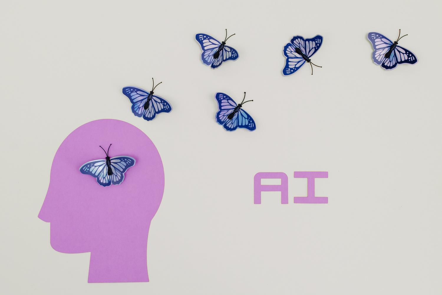 Ilustración conceptual minimalista de una silueta humana con mariposas emergiendo de su cabeza junto a las letras AI, representando la generación de ideas creativas mediante inteligencia artificial.