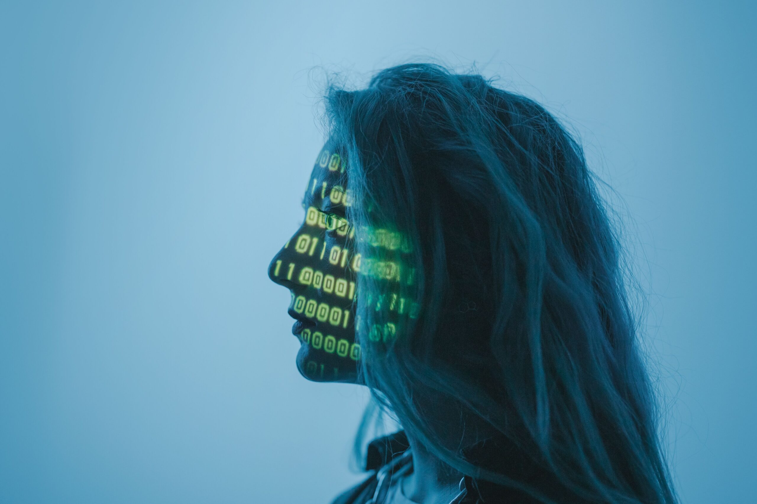 Perfil de una mujer con código binario proyectado, representando la gestión de datos y la privacidad en la IA.