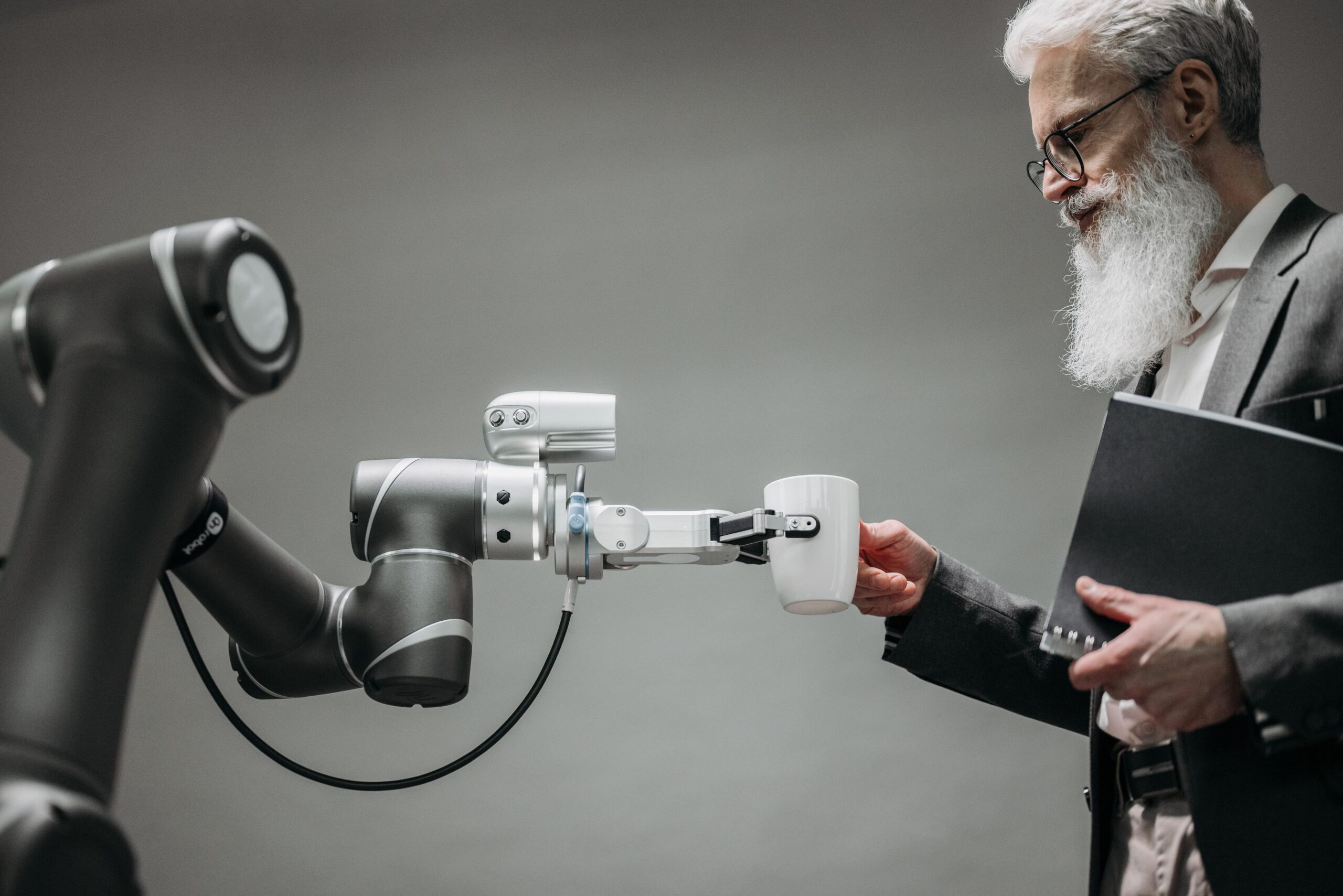 Un robot asistiendo a una persona mayor en un entorno moderno, representando el enfoque humanista de la inteligencia artificial.
