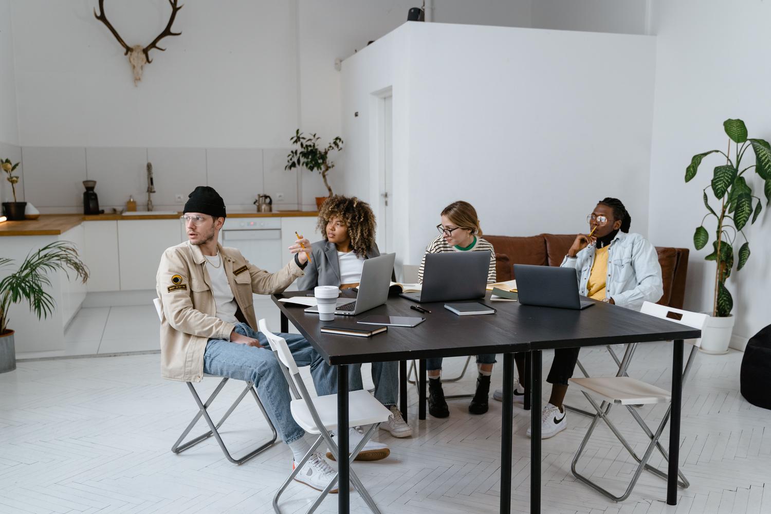 Equipo diverso de profesionales colaborando en una oficina moderna, representando las reuniones de alto valor y la sinergia humana.