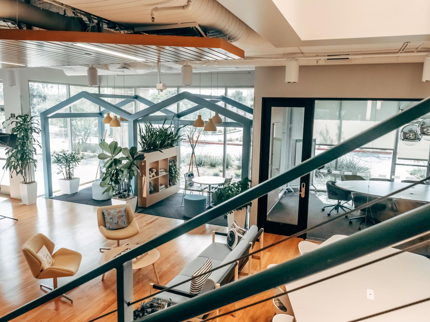 Interior de un espacio de coworking moderno y luminoso con plantas, destacando la importancia del entorno profesional.