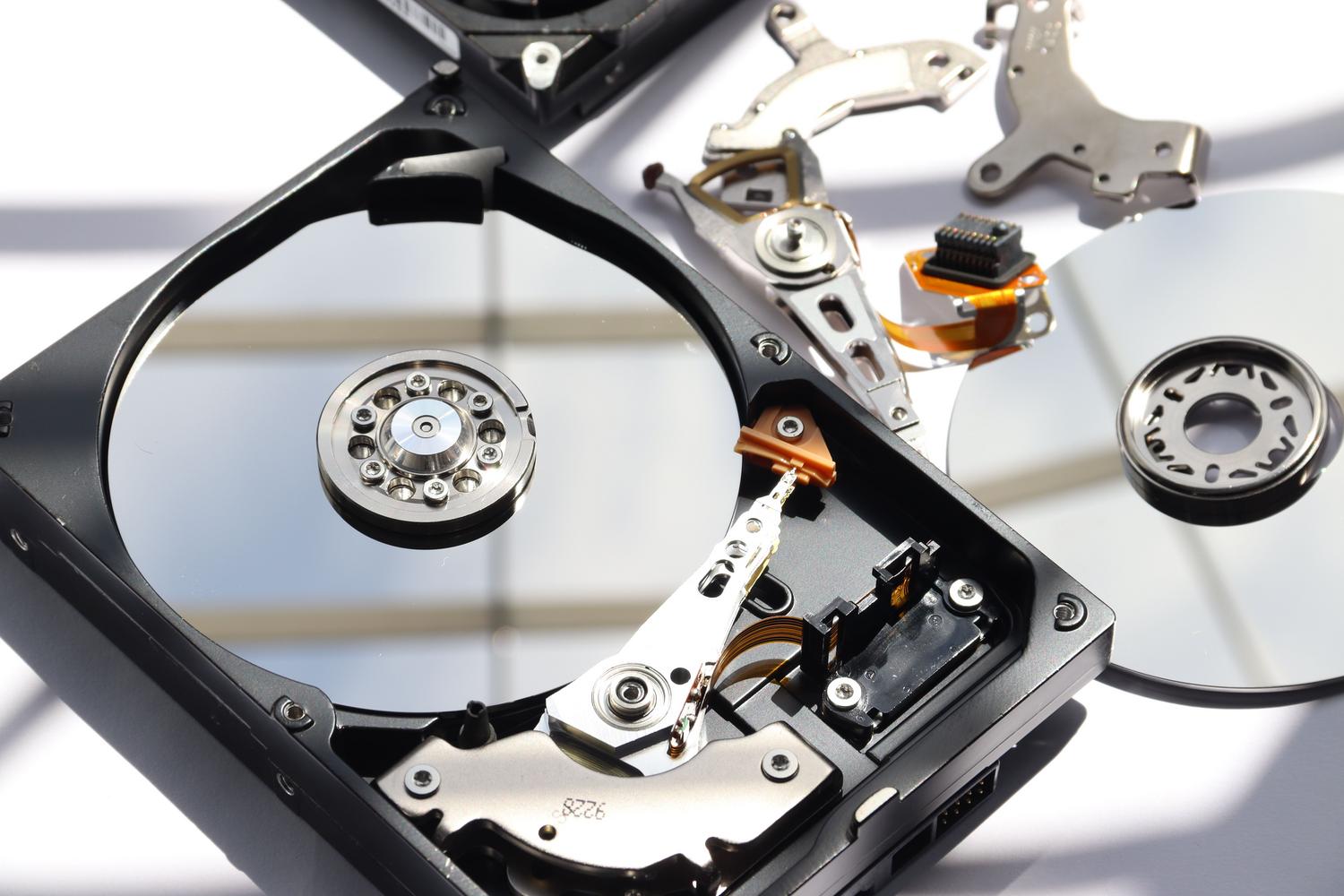 Vista detallada del interior de un disco duro mecánico HDD, ilustrando el hardware afectado por el borrado de particiones.