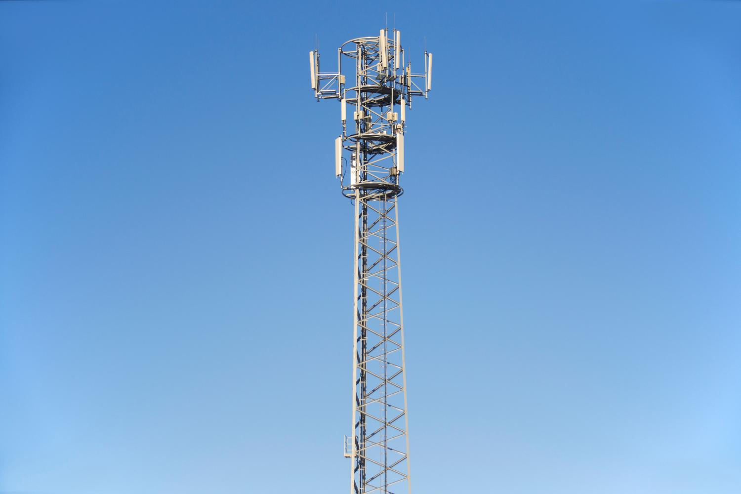 Torre de telecomunicaciones bajo un cielo azul representando la infraestructura de señal móvil