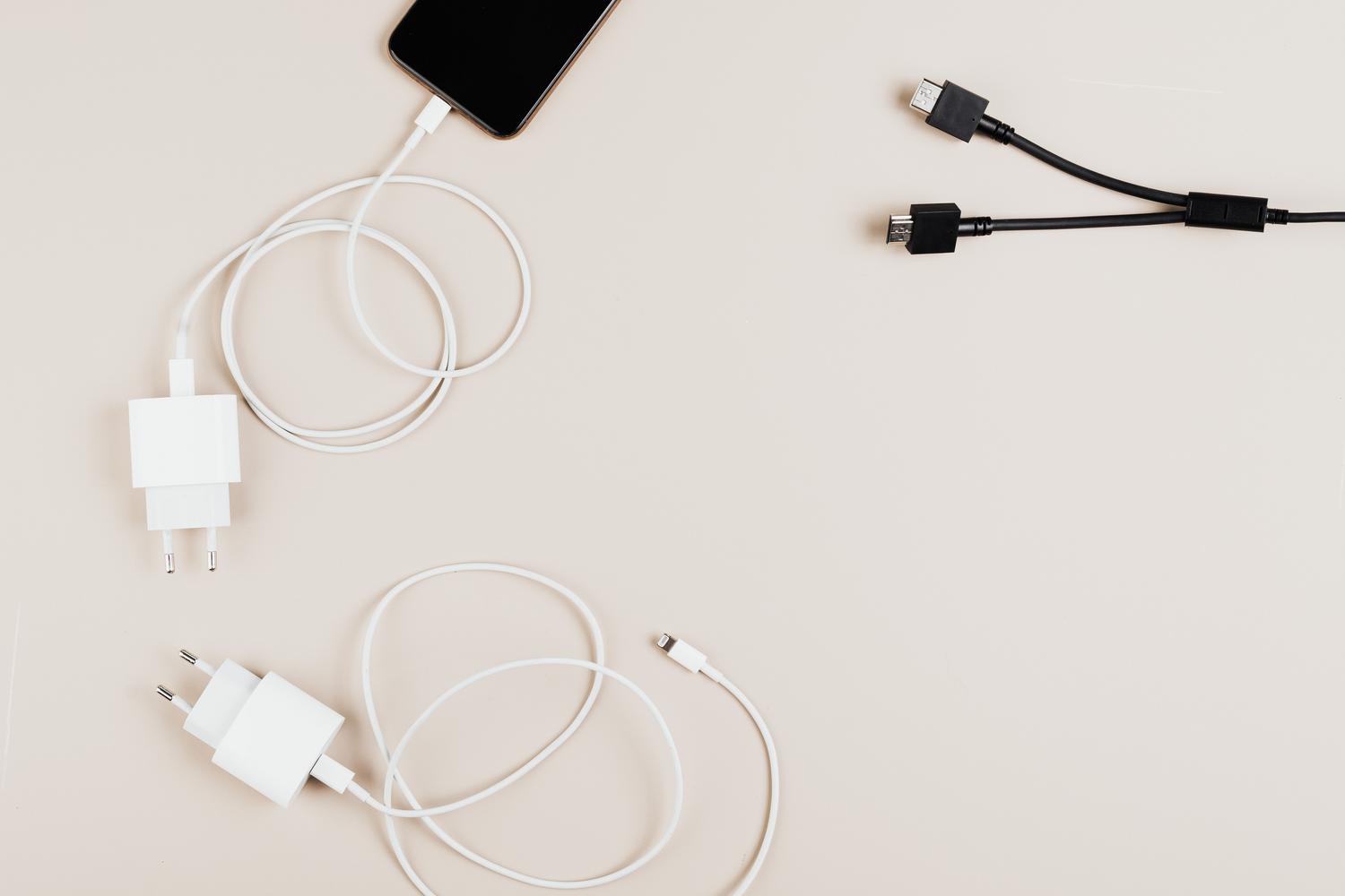 Colección de diversos cables USB y adaptadores de corriente para carga de móviles