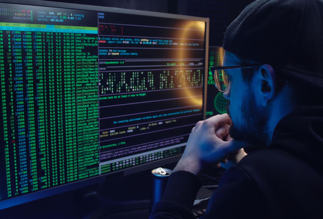 Analista de ciberseguridad trabajando con múltiples monitores que muestran terminales de Linux y herramientas de monitoreo de red.
