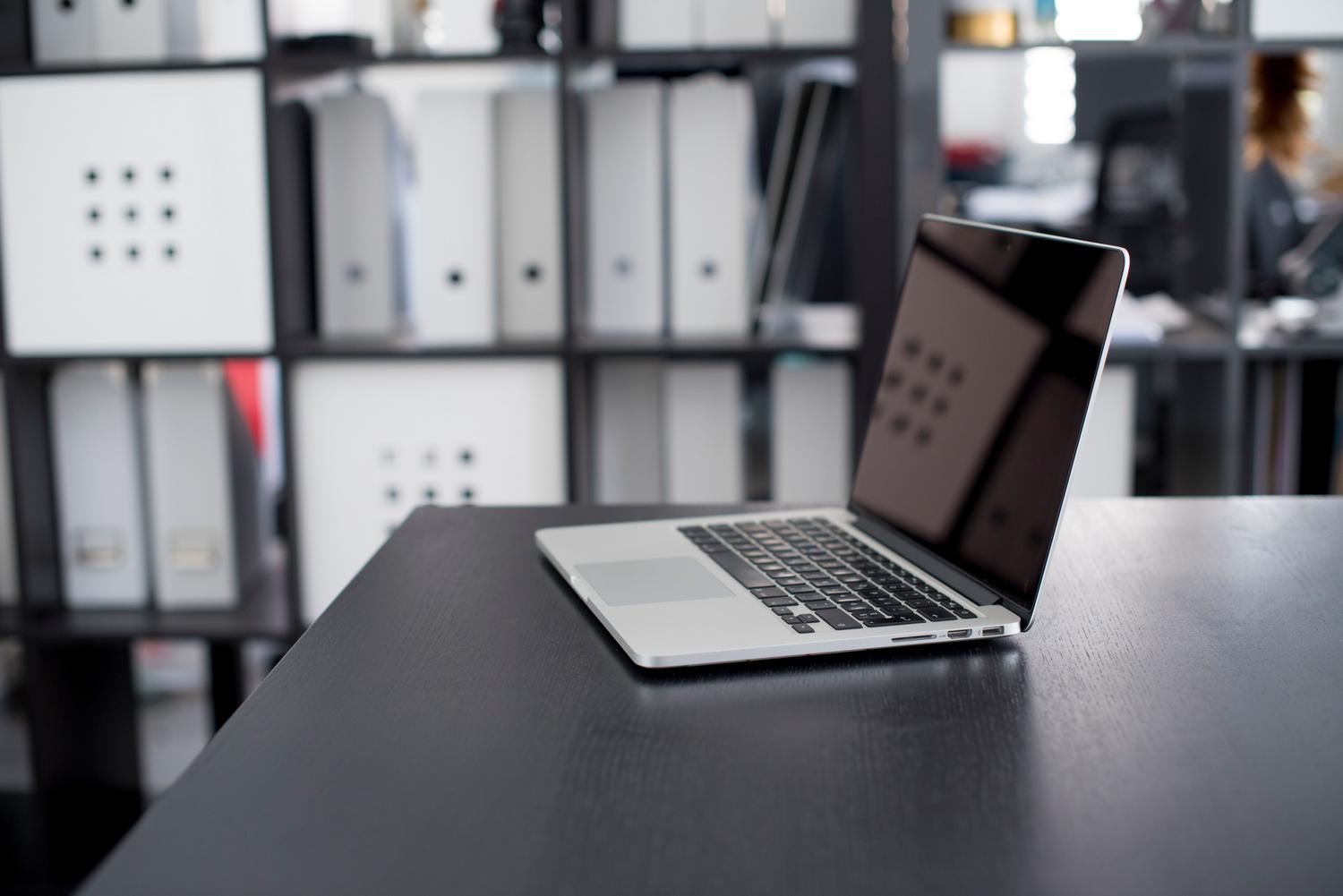 MacBook Pro en un entorno de oficina minimalista y organizado.
