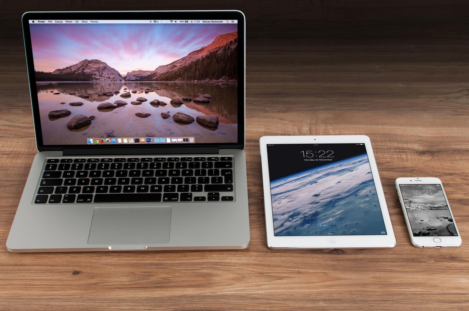 Conjunto de dispositivos Apple (MacBook, iPad e iPhone) sobre un escritorio profesional, representando el ecosistema gestionado por MDM.