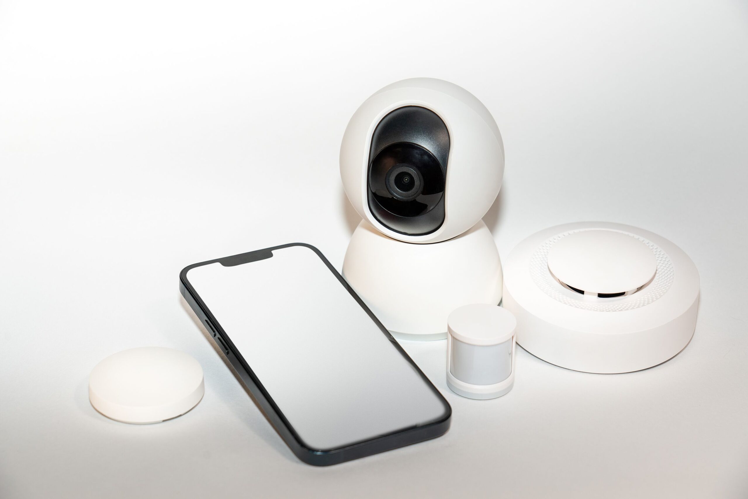Set de gadgets de seguridad para el hogar con un smartphone mostrando la interfaz de control