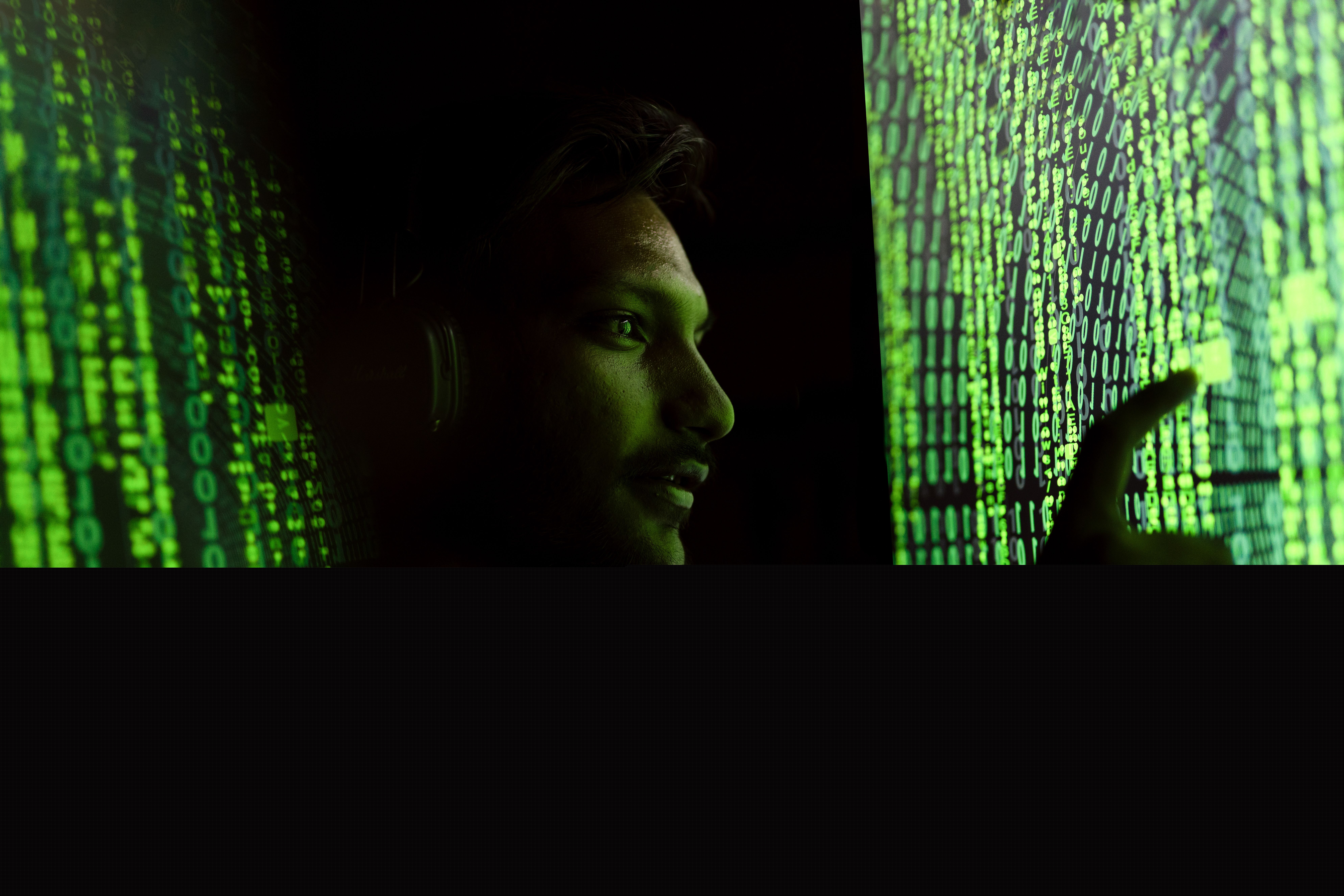 Persona interactuando con código digital que representa la monitorización y auditoría de seguridad en la nube Persona interactuando con código digital en una pantalla, representando la monitorización y auditoría de seguridad.