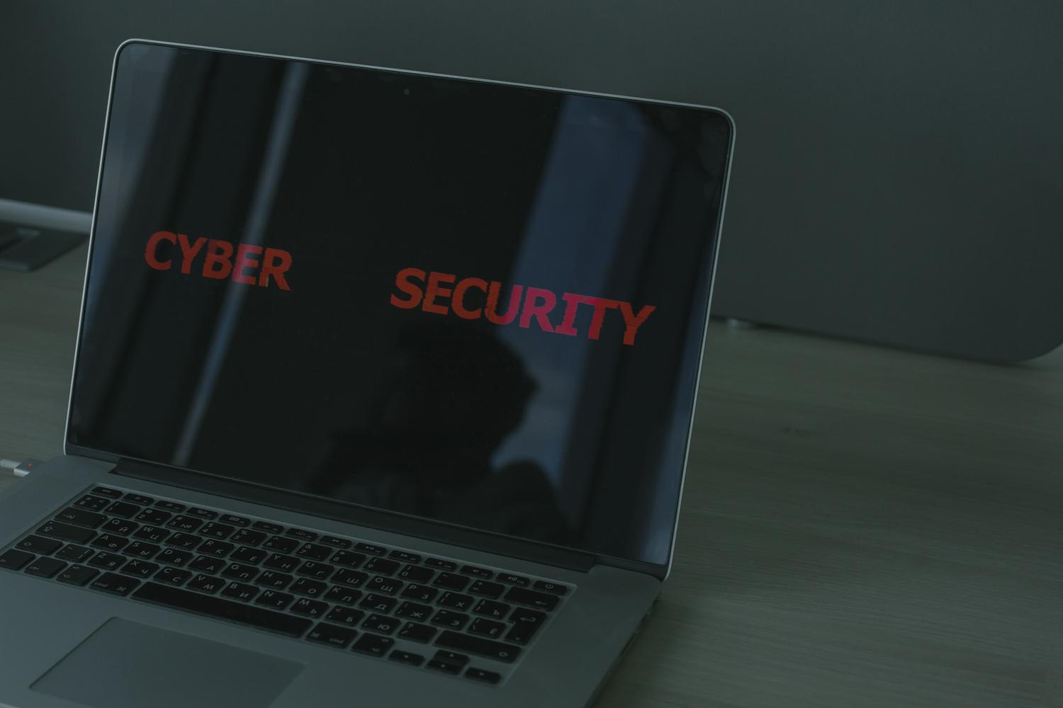 MacBook Pro con texto de ciberseguridad en pantalla, representando la protección de datos y el cifrado en macOS.