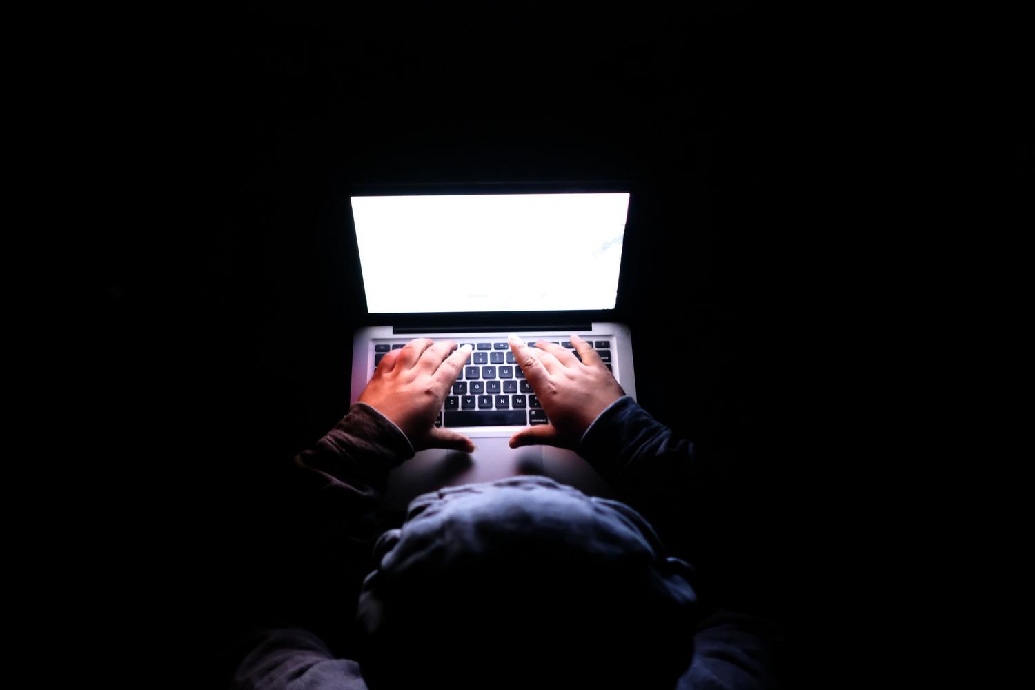 Persona analizando seguridad informática en un MacBook en un entorno oscuro, representando la privacidad y la auditoría técnica.