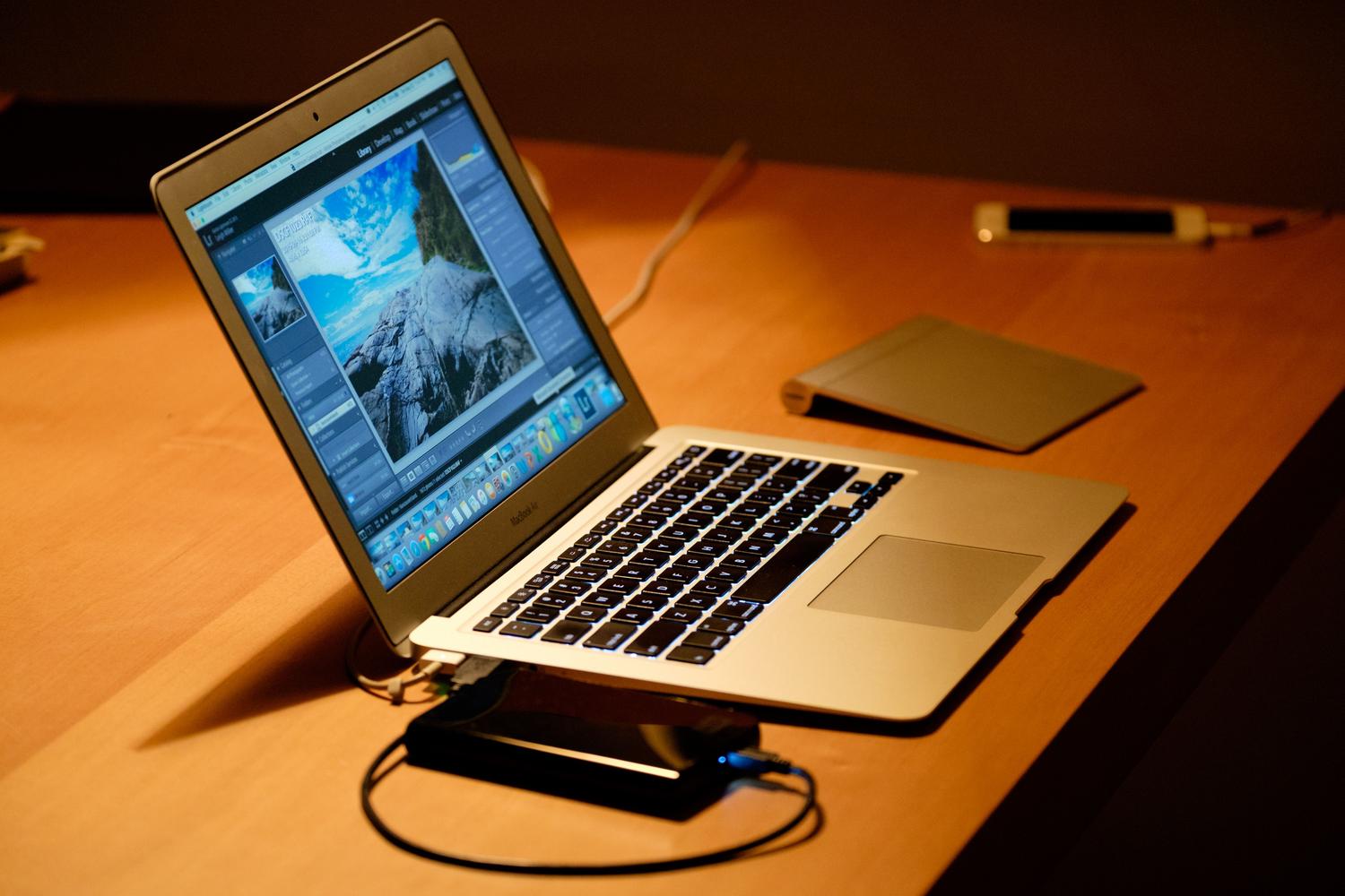 Espacio de trabajo digital minimalista con un portátil sobre una mesa de madera, aportando un estilo visual limpio y profesional al artículo.