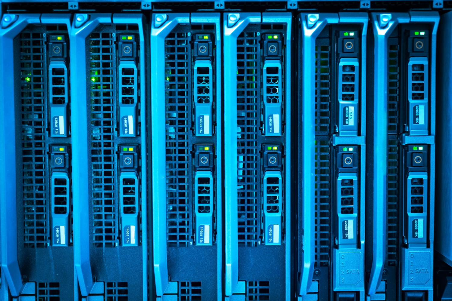 Racks de servidores iluminados en un centro de datos, representando el almacenamiento en la nube y la regla de respaldo 3-2-1.