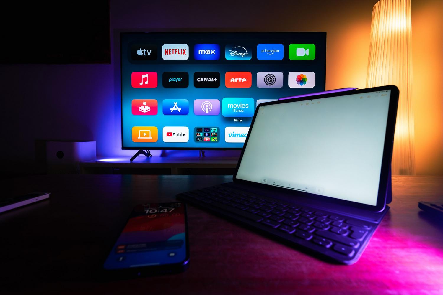 Configuración de hogar moderno con Smart TV y tablet mostrando diversas aplicaciones de streaming.
