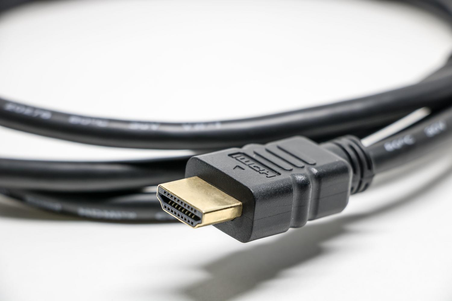 Primer plano de un cable HDMI de alta calidad con conectores dorados para optimizar la señal de TV.