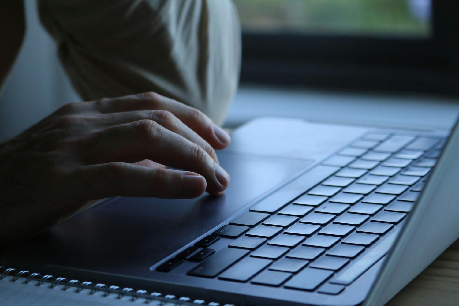 Primer plano de manos escribiendo en el teclado para ejecutar comandos de reparación en el Símbolo del sistema