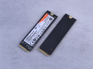 Primer plano de unidades SSD NVMe sobre una superficie gris, representando el hardware de almacenamiento moderno.