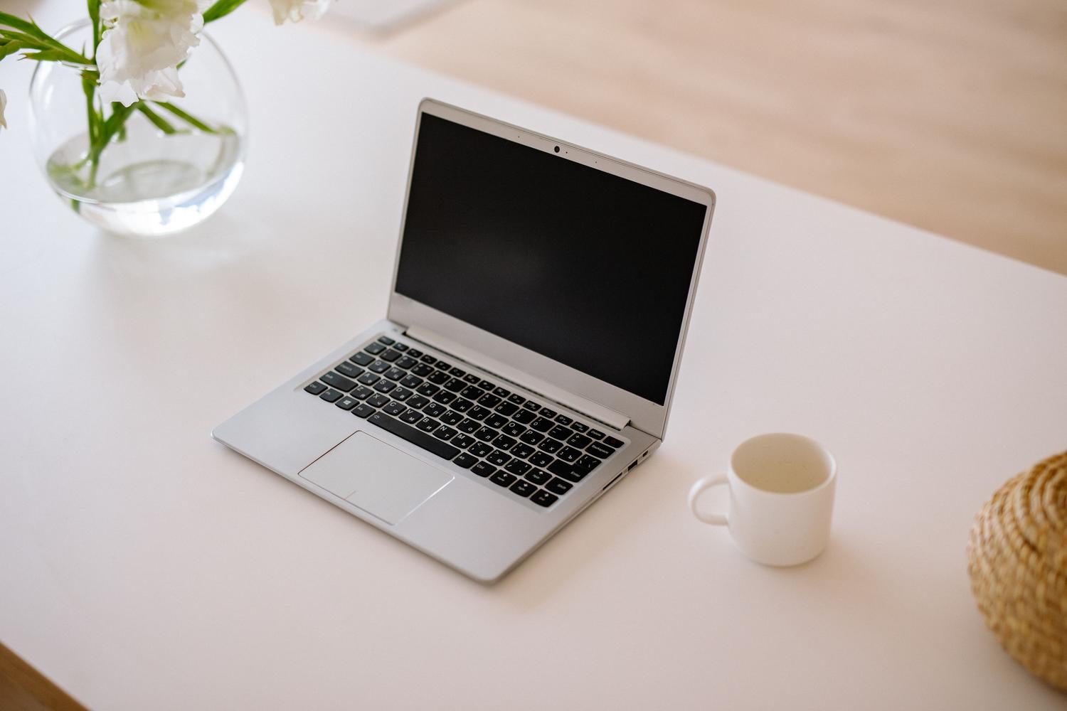 Espacio de trabajo minimalista con laptop abierta, taza de café y luz natural, evocando concentración y eficiencia. Espacio de trabajo minimalista con laptop abierta, taza de café y luz natural, evocando concentración y eficiencia.
