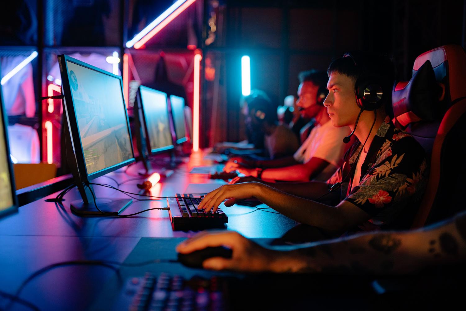 Grupo de jugadores profesionales en una arena de esports con iluminación de neón, representando la ventaja competitiva de los 120Hz.