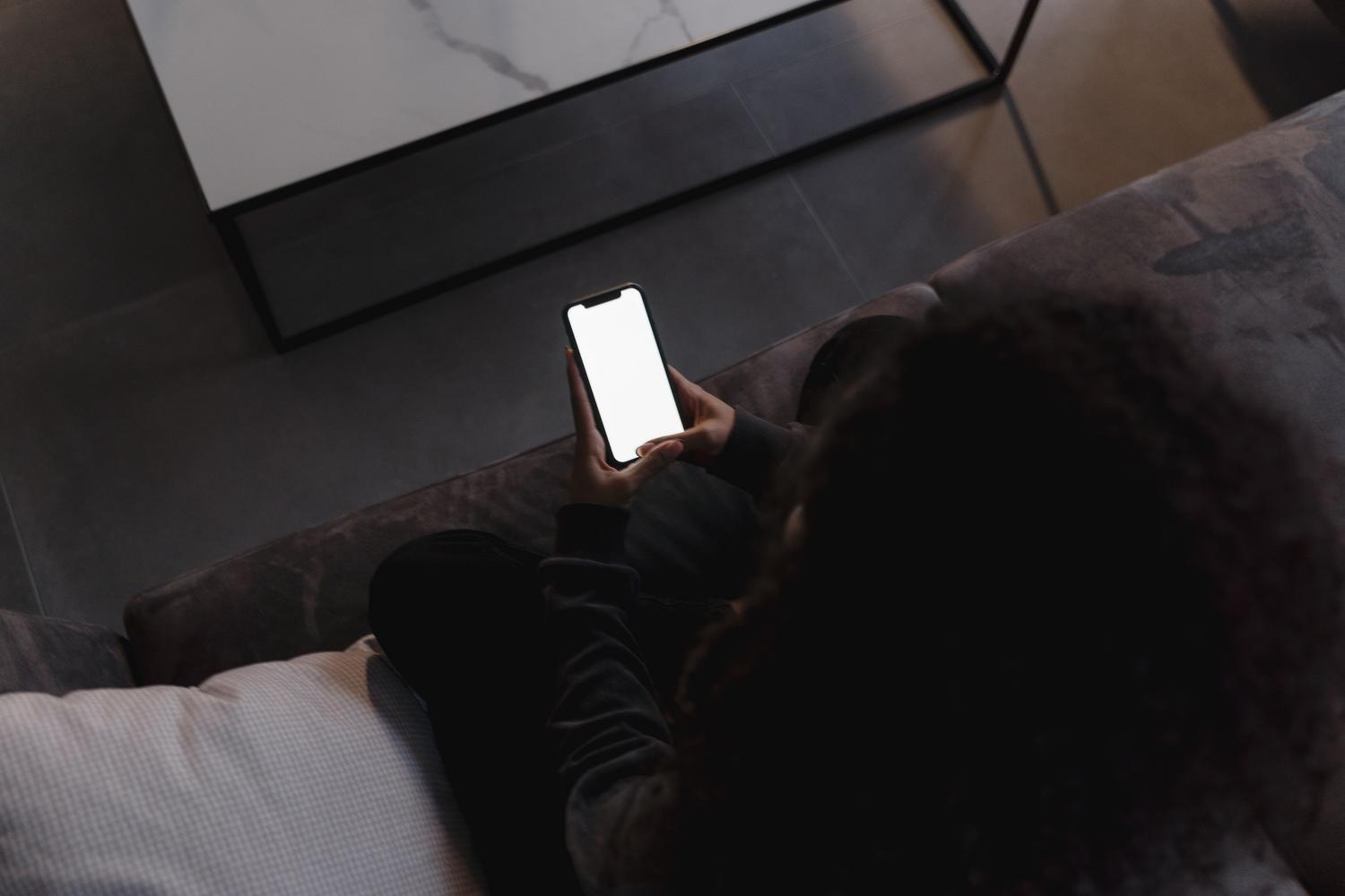 Person holding a smartphone with a bright screen in a modern setting, ideal for demonstrating Android Developer Options.