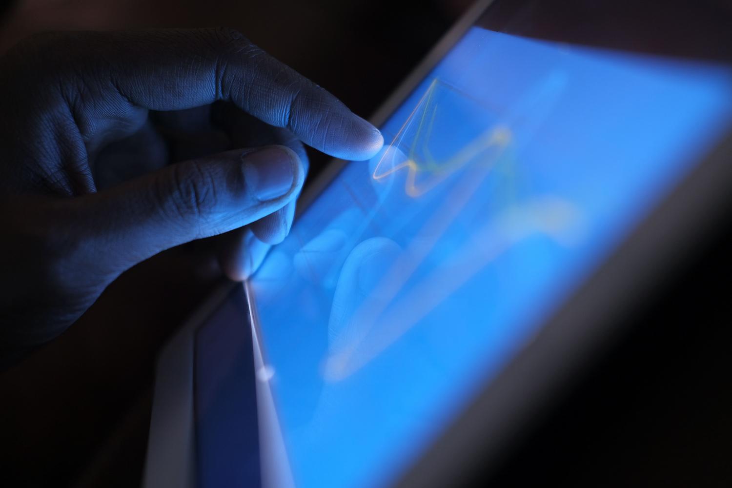 Detalle de un dedo interactuando con la pantalla táctil de una tablet, representando la configuración de gestos.