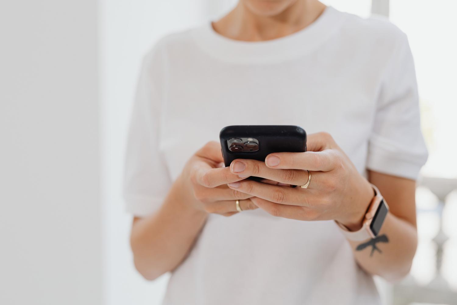 Persona utilizando un smartphone con un estilo minimalista y luminoso, ideal para ilustrar la navegación táctil.