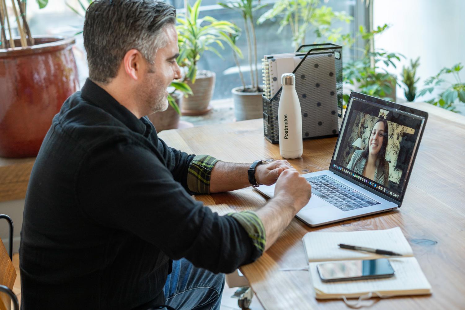 Hombre trabajando en remoto en una videollamada desde su espacio de trabajo en casa. Hombre trabajando en remoto en una videollamada desde su espacio de trabajo en casa.