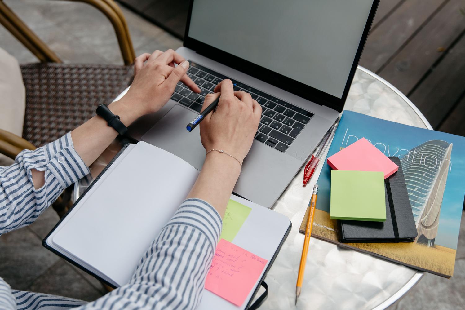 Espacio de trabajo minimalista con un portátil y notas adhesivas, simbolizando la eficiencia y la organización.