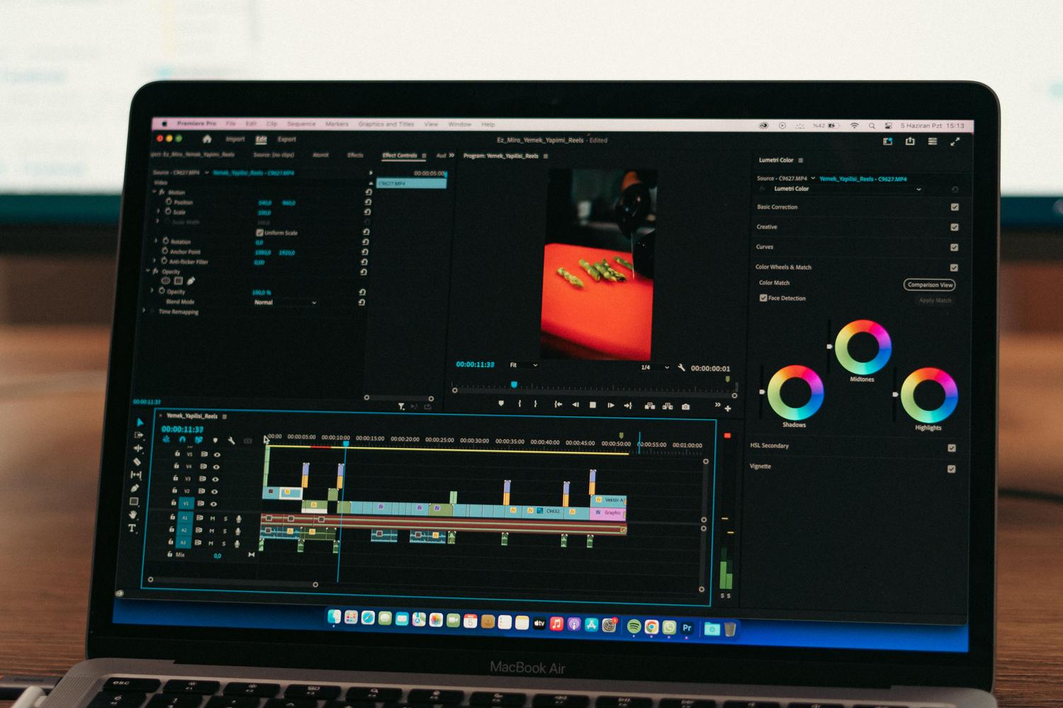 Primer plano de un portátil mostrando software de procesamiento de vídeo en un entorno profesional.