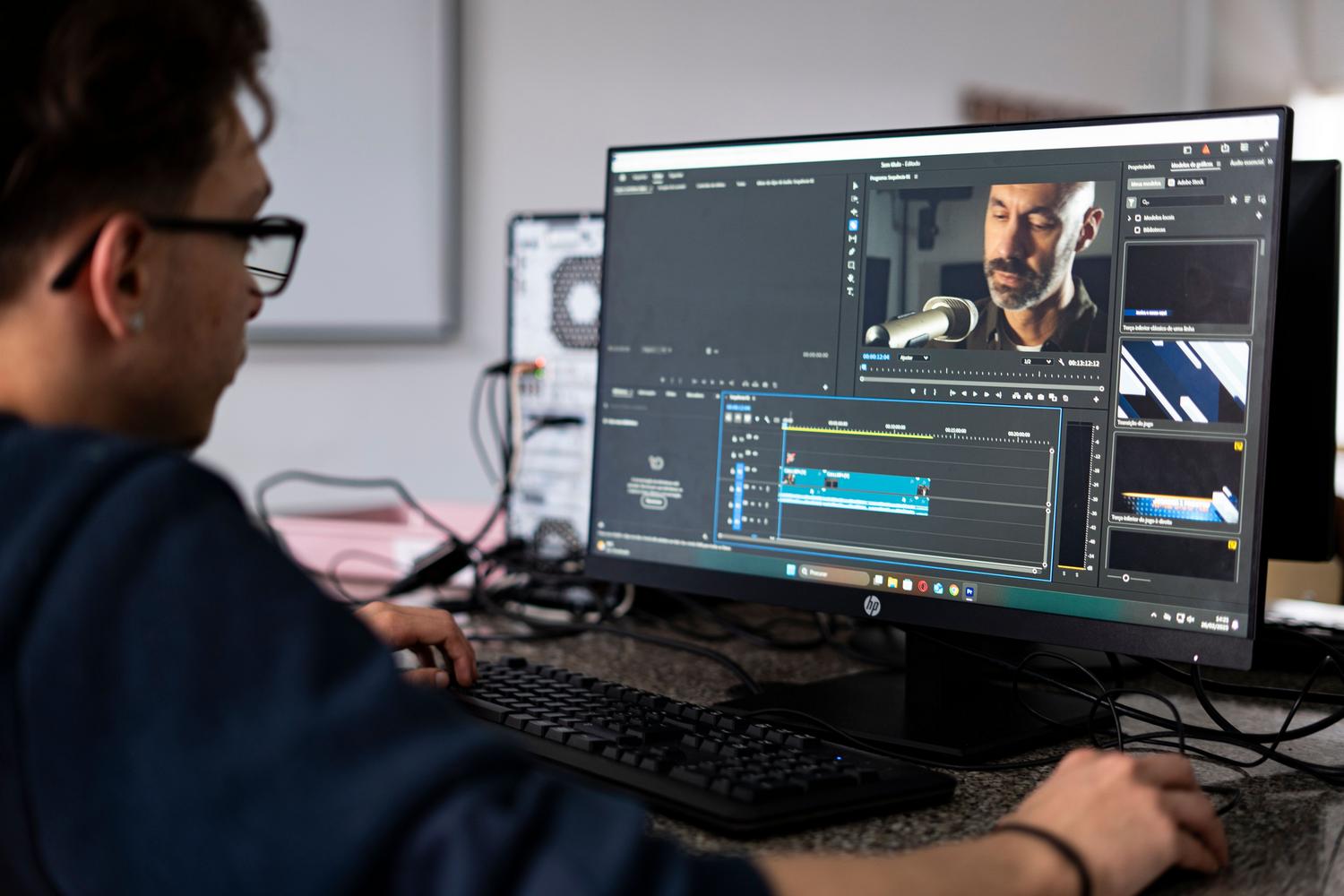 Editor de vídeo trabajando en un proyecto en un ordenador de escritorio en una oficina moderna.