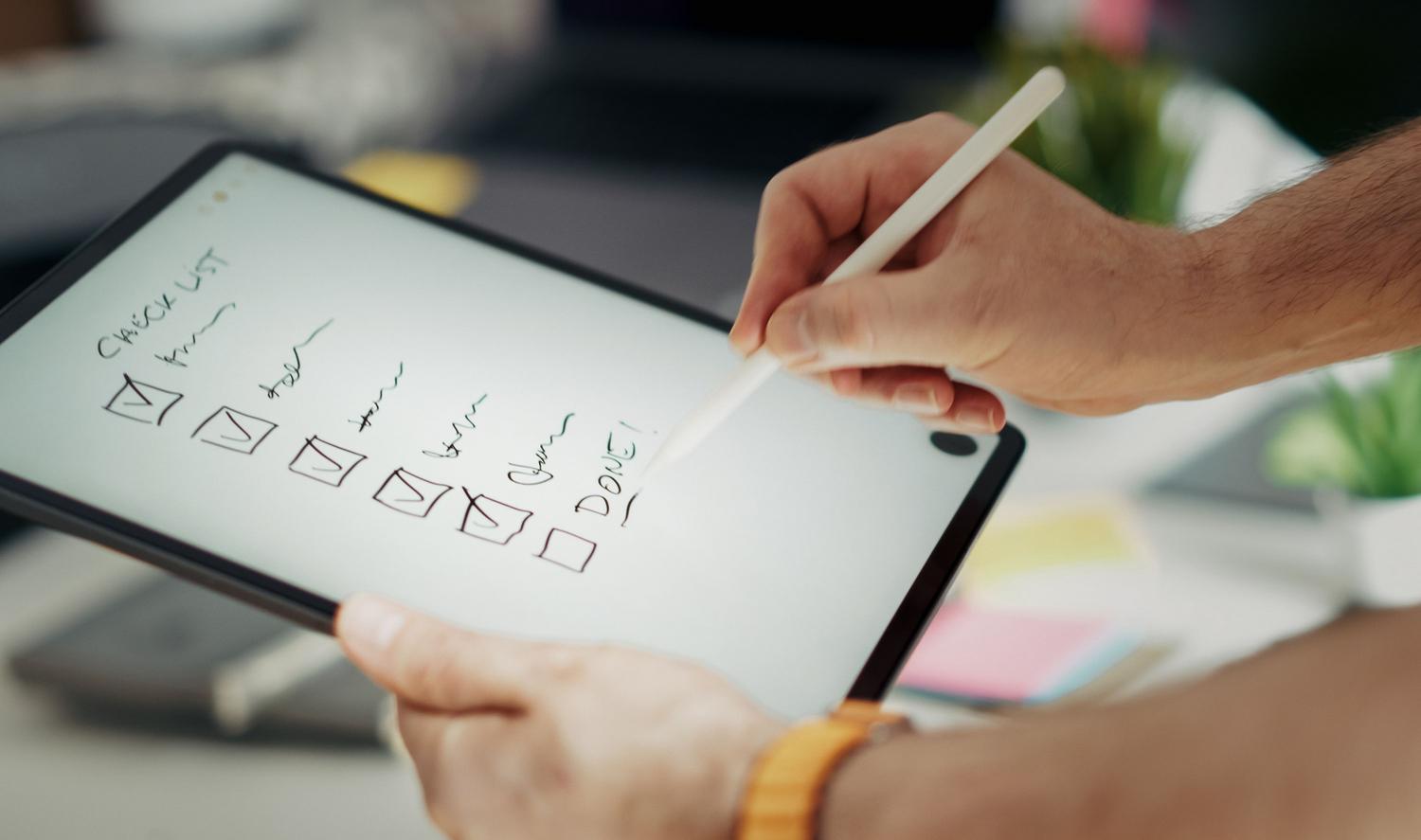 Primer plano de una mano utilizando un lápiz digital sobre una tableta para marcar una lista de tareas, ilustrando el procesamiento deliberado de flujos de trabajo. Primer plano de una mano utilizando un lápiz digital sobre una tableta para marcar una lista de tareas, ilustrando el procesamiento deliberado de flujos de trabajo.