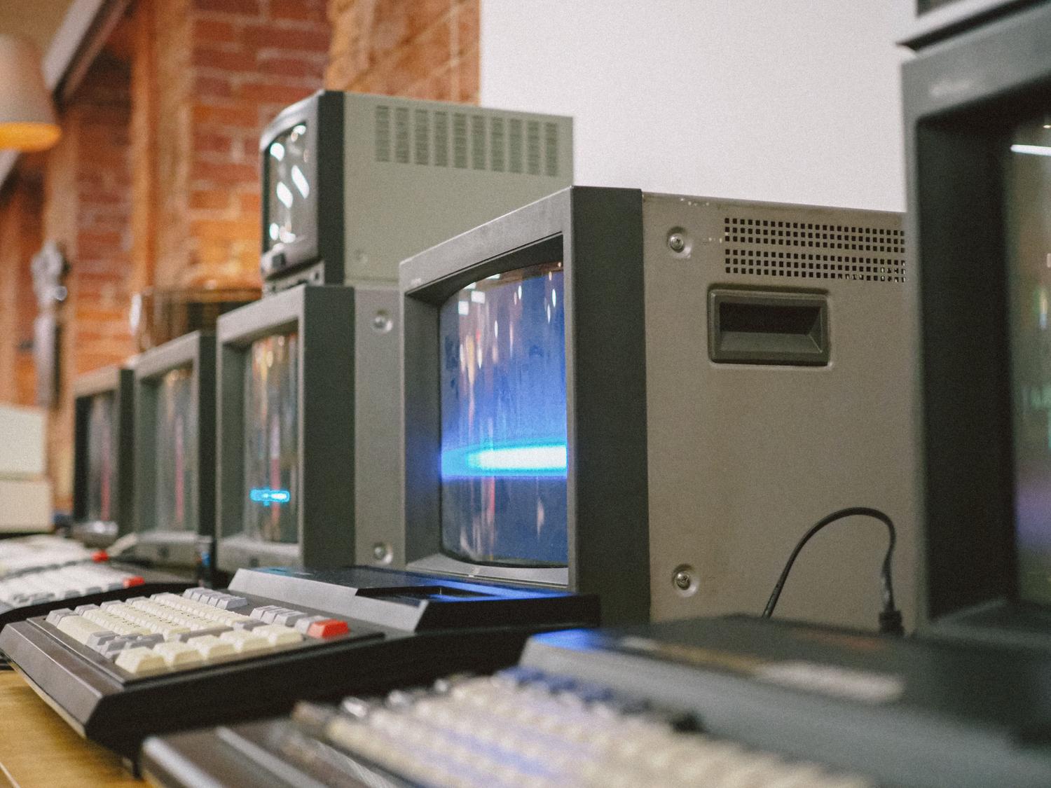Fila de monitores CRT antiguos, evocando la estética del hardware original para el cual fueron diseñados los juegos clásicos.