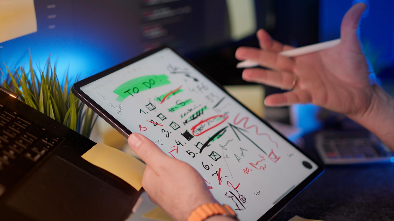 Primer plano de una persona organizando tareas en una tablet con un lápiz digital, simbolizando la priorización y gestión de flujos de trabajo.