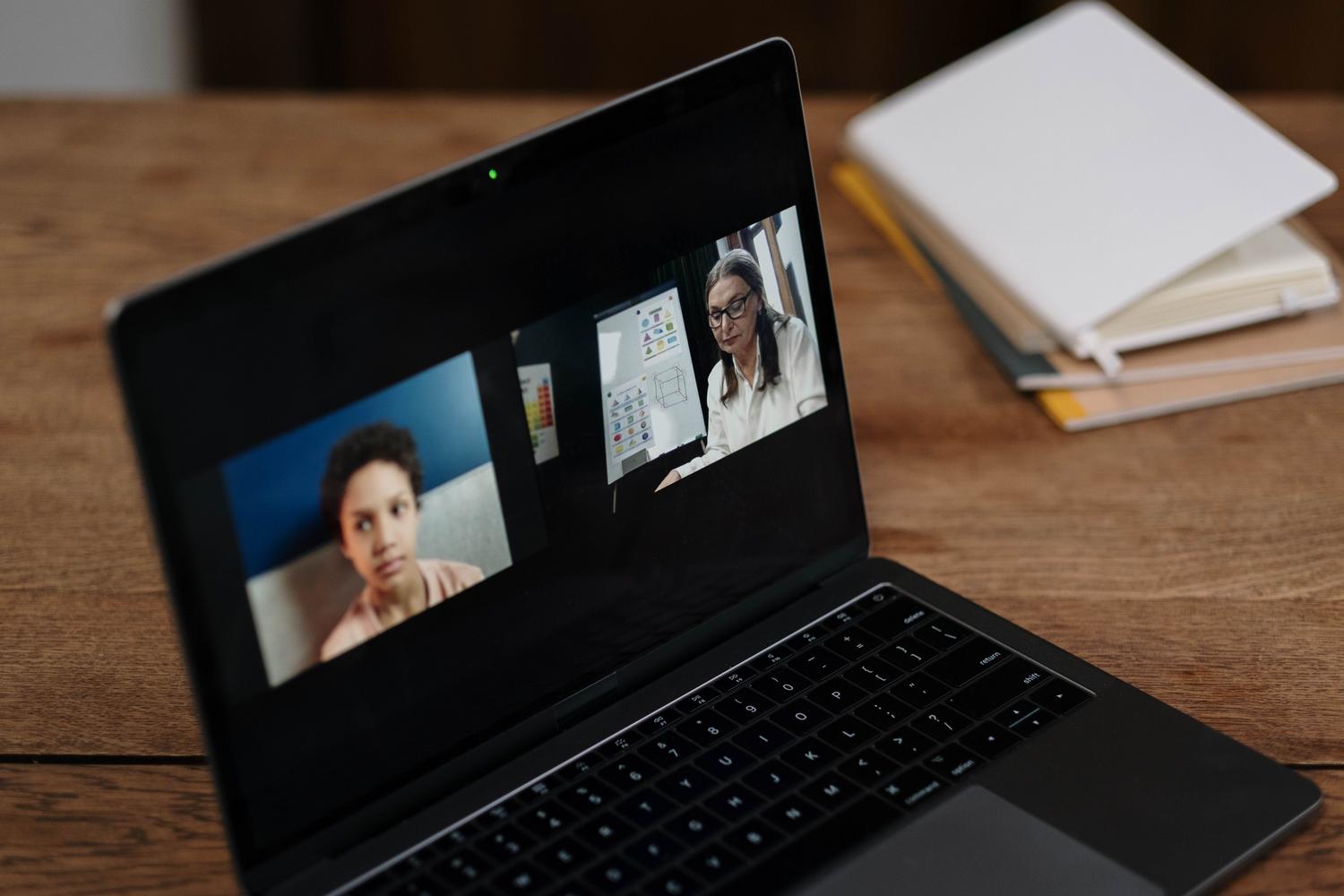 Dos personas interactuando en un entorno de educación virtual a través de un portátil