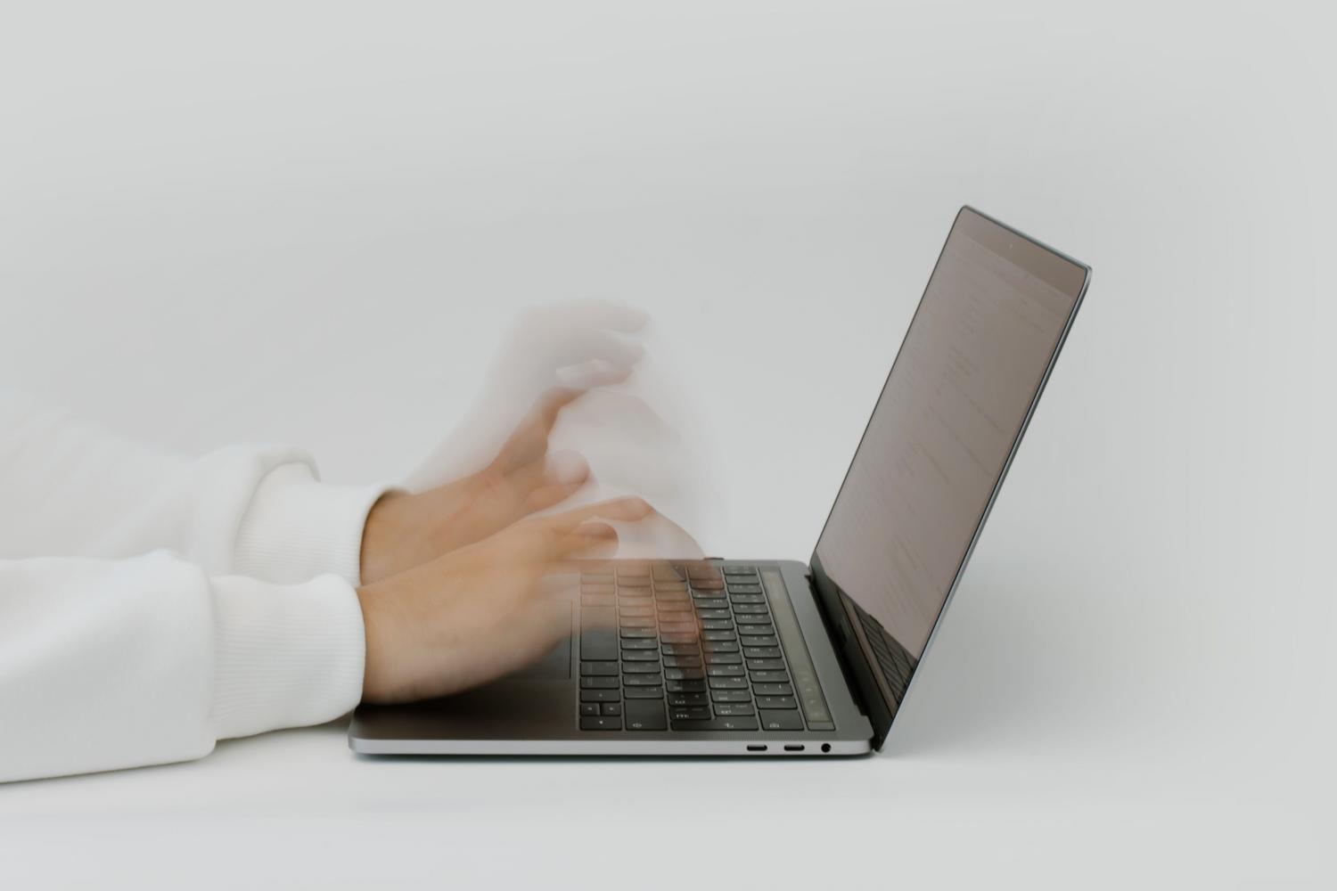 Manos escribiendo rápidamente en el teclado de un portátil, simbolizando la velocidad y eficiencia del navegador.