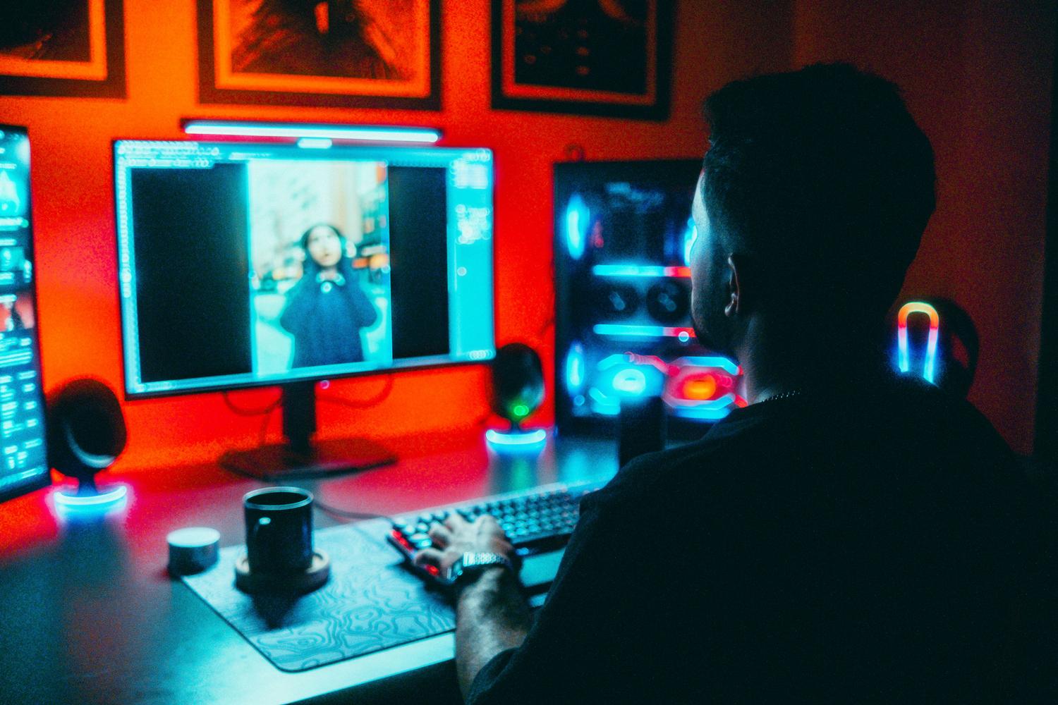 Fotógrafo profesional editando imágenes en un entorno con luces neón, ilustrando la creación de perfiles de color personalizados para creadores.