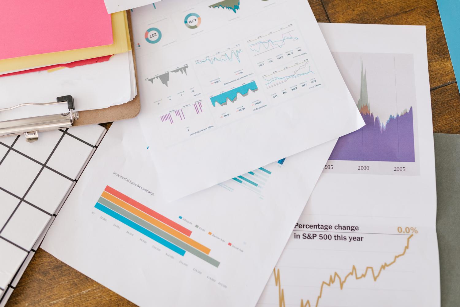 Primer plano de informes de analítica empresarial con gráficos y tablas sobre un escritorio de oficina