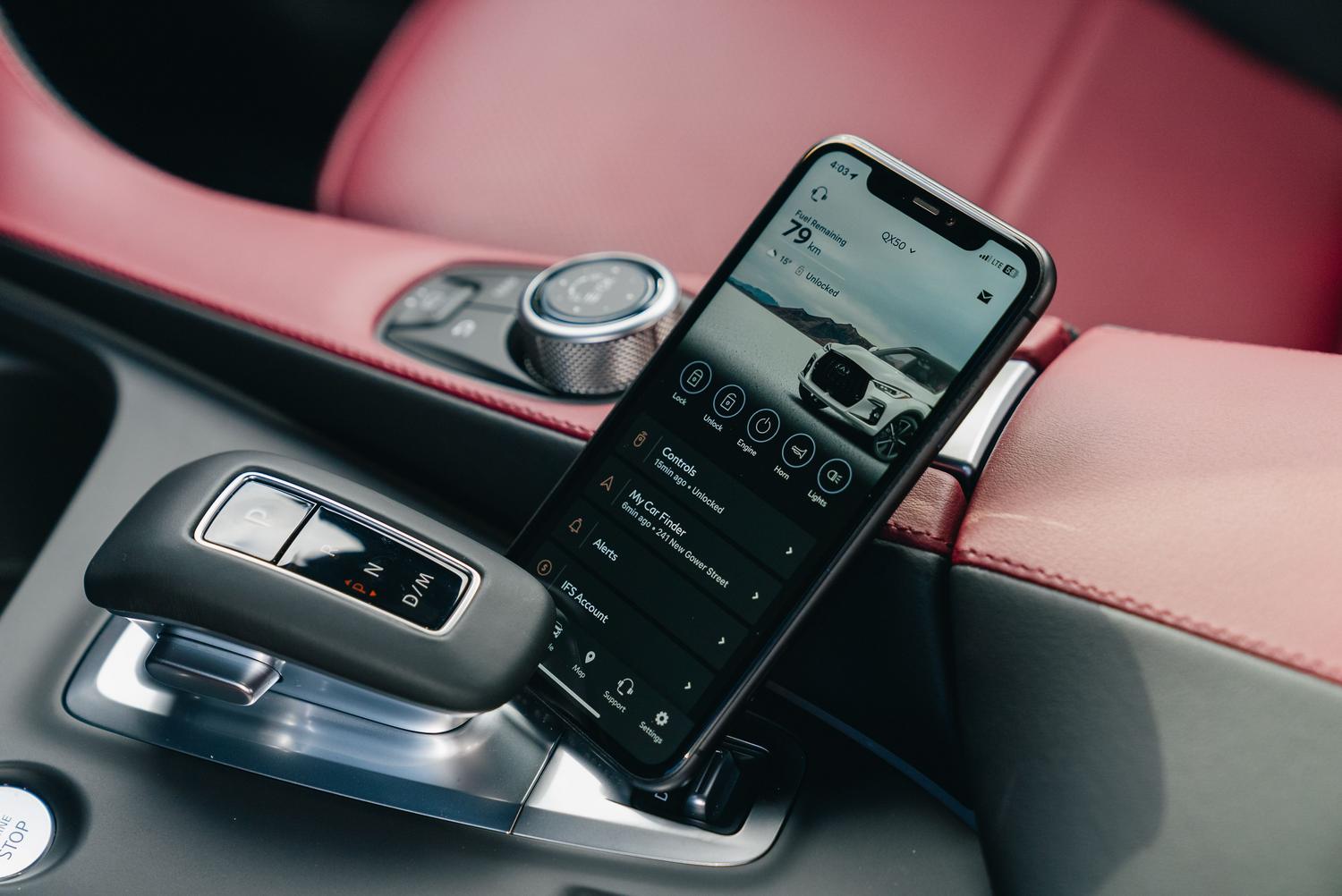 Smartphone con una aplicación de control de coche en el interior de un vehículo de lujo, ilustrando las llaves digitales.
