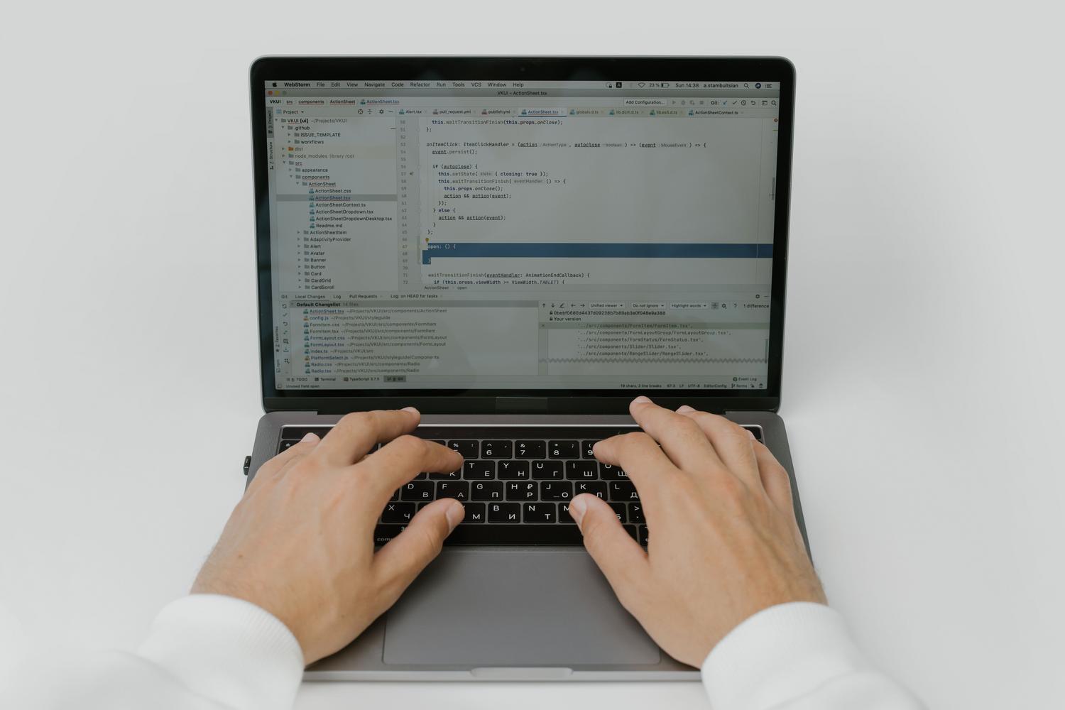 Manos de un desarrollador escribiendo código en el teclado de un portátil, simbolizando la acción de corregir y recompilar la solución.
