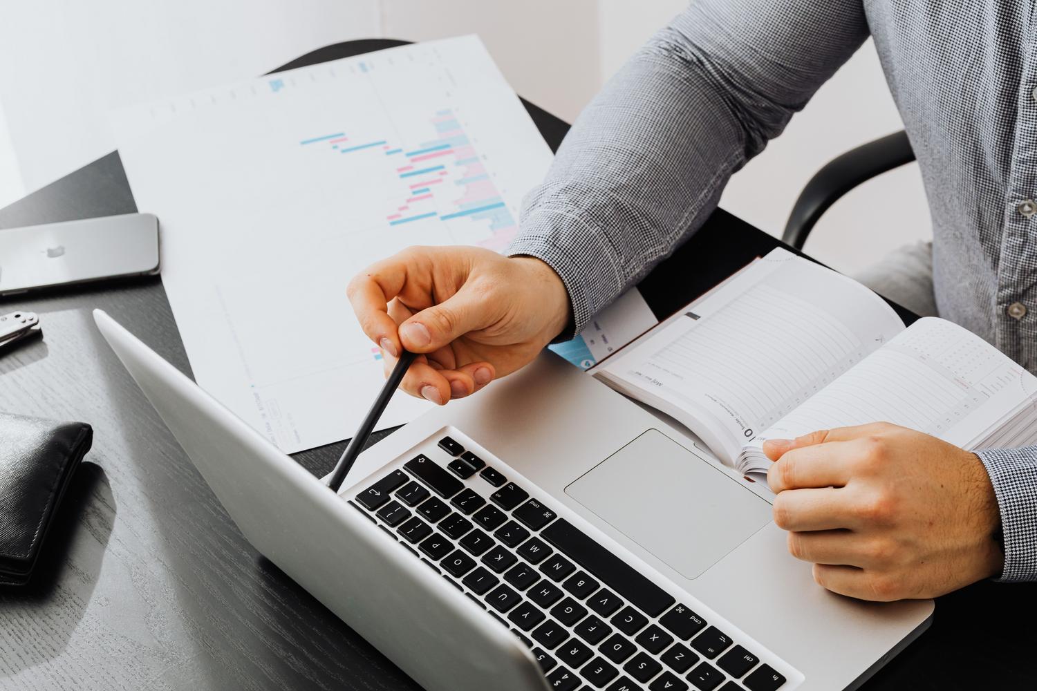 Escritorio de oficina moderno con ordenador y un informe de cronograma, simbolizando la planificación y automatización.