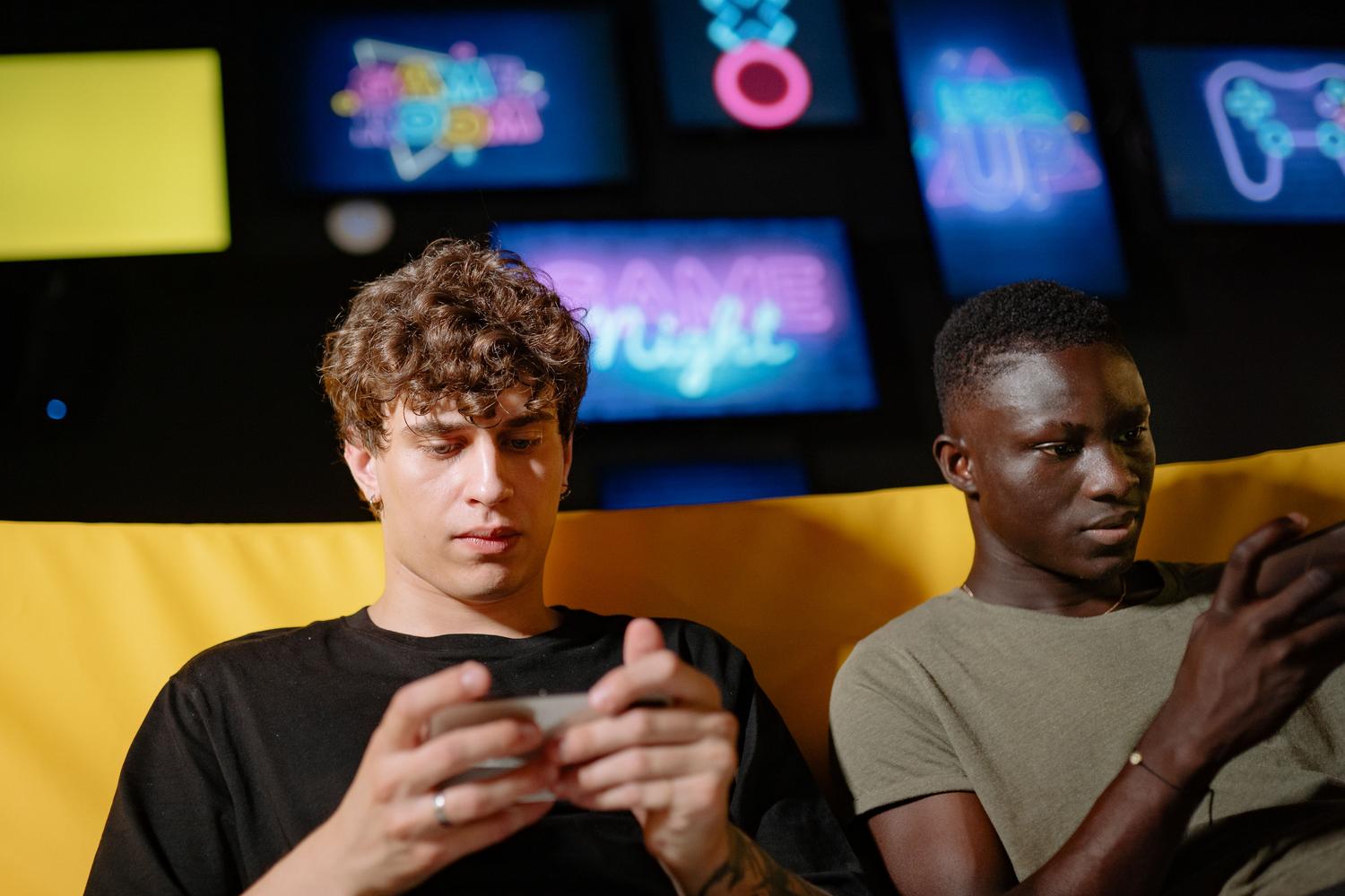 Dos amigos utilizando sus smartphones para coordinar una partida de videojuegos y chatear en tiempo real