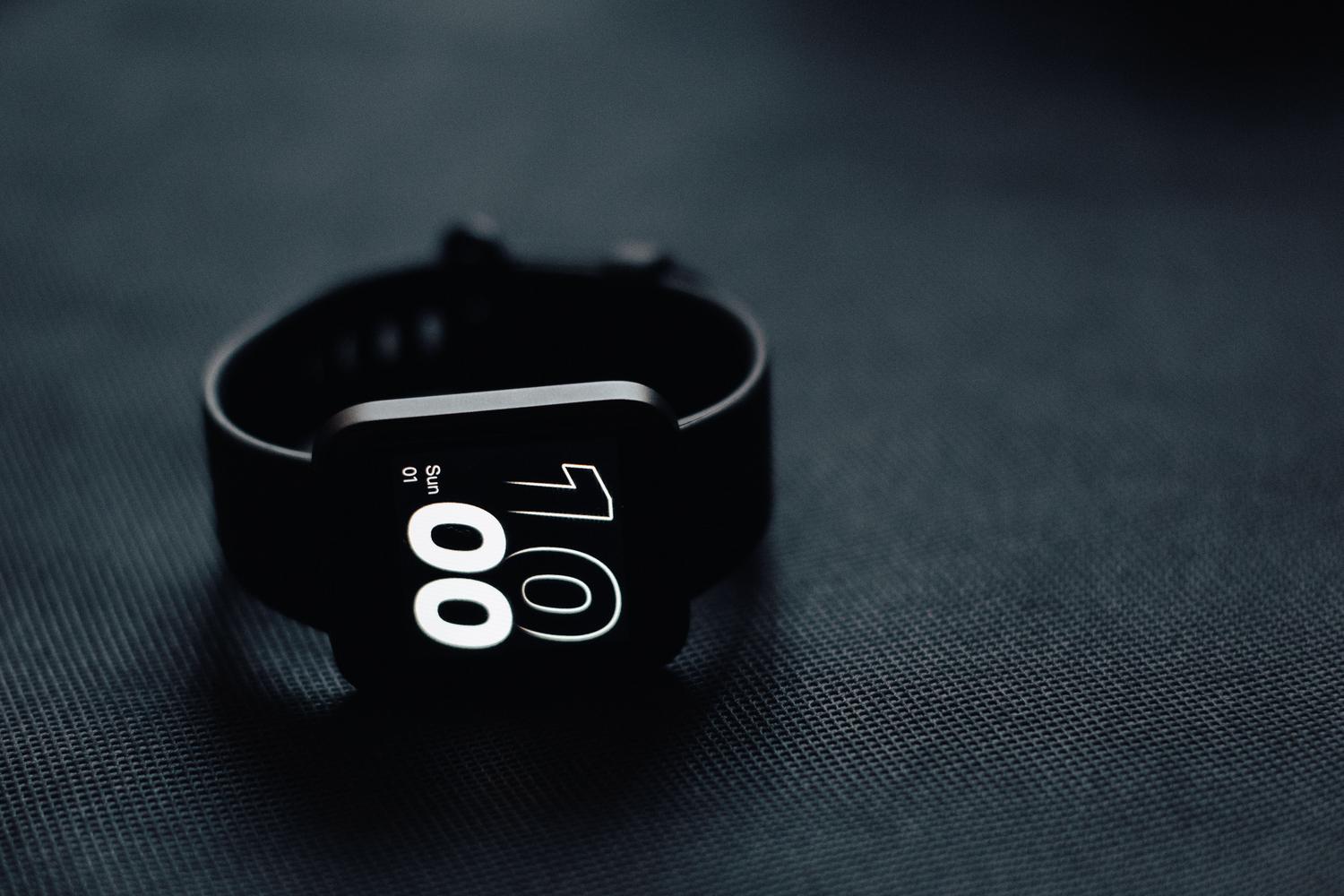 Fotografía minimalista de un smartwatch moderno sobre una superficie oscura, representando la optimización de energía en dispositivos Wear OS.