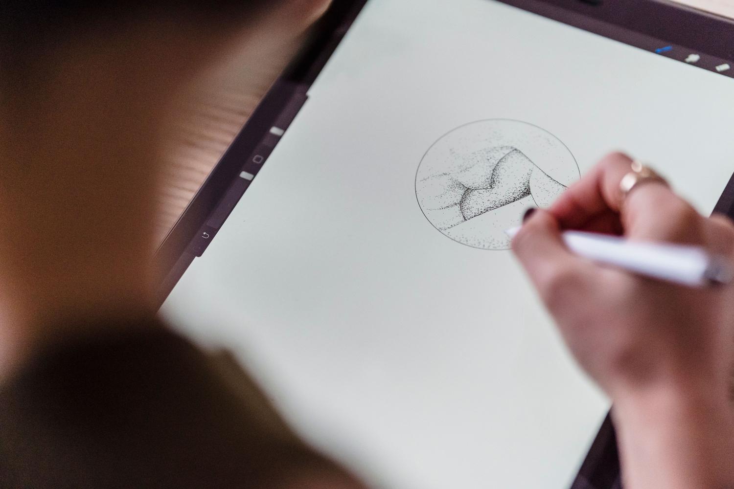 Vista cenital de un artista dibujando con un lápiz digital sobre una tableta gráfica. Vista cenital de un artista dibujando con un lápiz digital sobre una tableta gráfica.